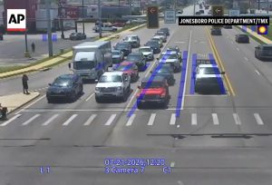 Spider-Man helps a man in a wheelchair cross the street