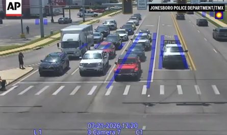 Spider-Man helps a man in a wheelchair cross the street